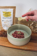 Hokuō® Dandelion Extract powder being sprinkled into pet food bowl for digestion and urinary health support
